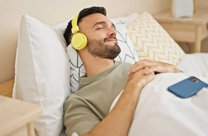 müzik dinleyerek uyuyan bir adam