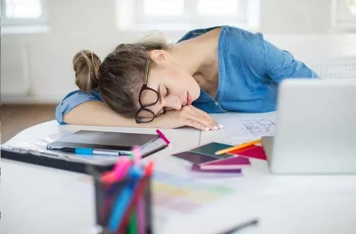 Çalışma masasında uyuklayan bir kadın
