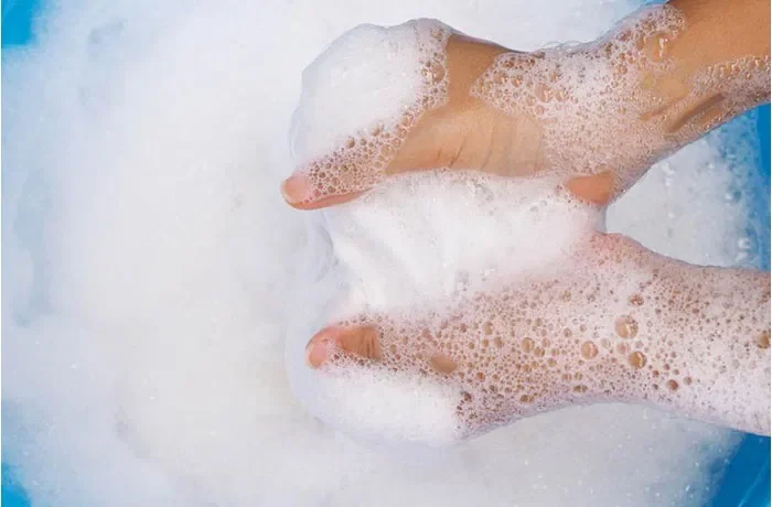 Elinde çamaşır suyu köpüğü tutan biri