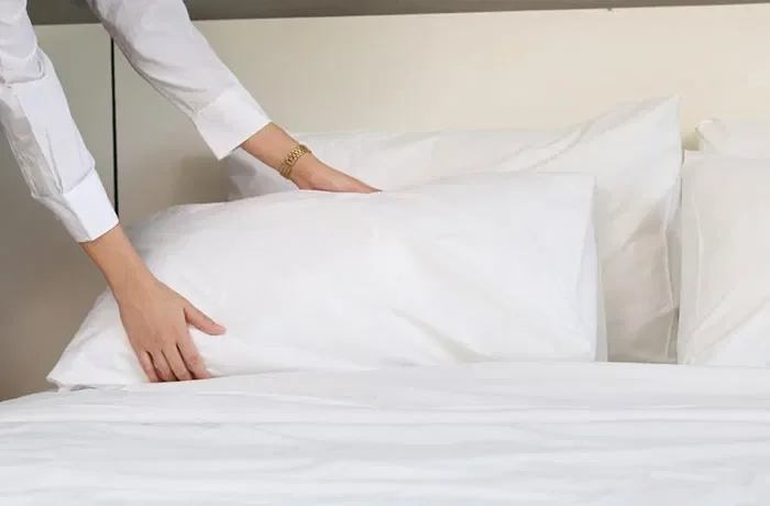 Yastığı yatağa yerleştiren bir kadın