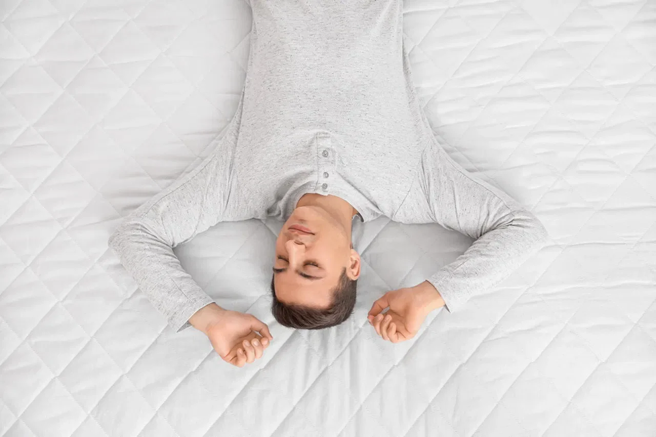 Yatağa sırtüstü uzanan bir adam