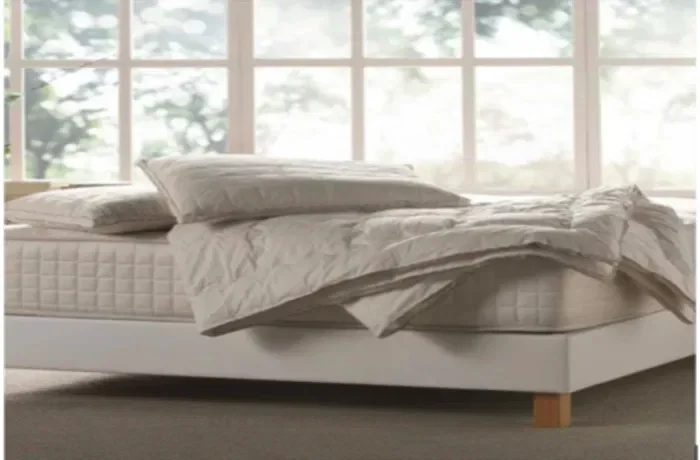 Beyaz yatağın üstünde yastık ve yorgan