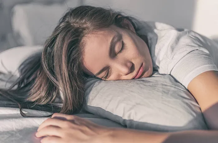 Gri yastığa başını koymuş uyuyan biri