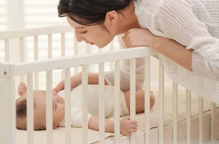 uyuyan bebeğe bakan bir kadın