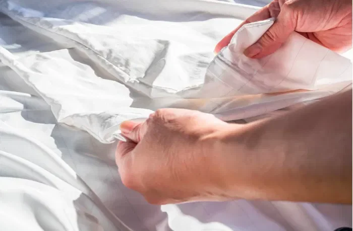Yatak örtüsünü inceleyen bir adam