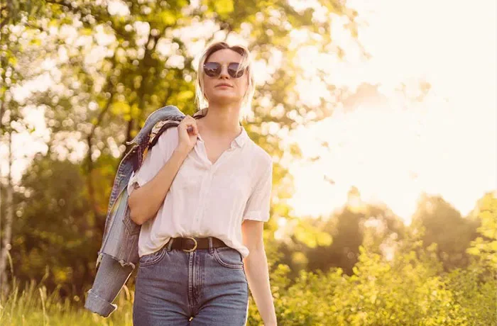 Ormanda yürüyen gözlüklü bir kadın