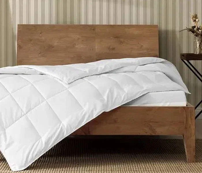 bambu yorgan serili bir yatak ve ahşap baza