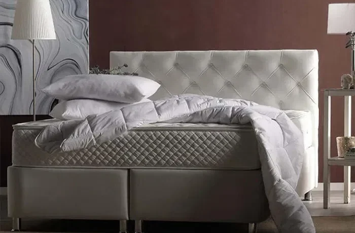 İki yastık ve yorganın bulunduğu bir yatak