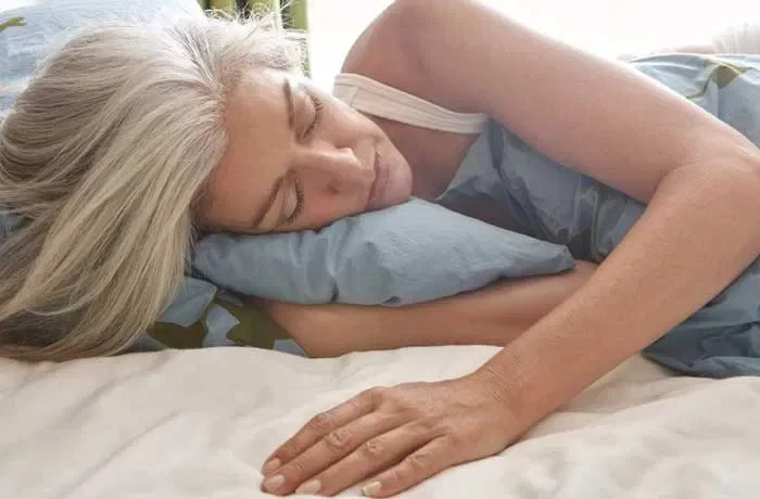 Bir elini yastığın altına koymuş bir kadın