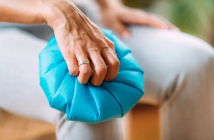 Bacağına kompress uygulayan biri