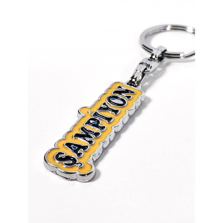 Sarı Üzerine Lacivert  “Şampiyon” Yazılı Metal Anahtarlık – Başarının ve Özgüvenin Simgesi