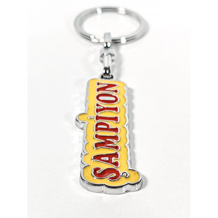 Şampiyon Yazılı Sarı Kırmızı Metal Anahtarlık – Enerjik Tasarım ve Güçlü Duruşun Eğlenceli İfadesi
