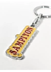 Şampiyon Yazılı Sarı Kırmızı Metal Anahtarlık – Enerjik Tasarım ve Güçlü Duruşun Eğlenceli İfadesi