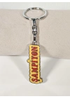 Şampiyon Yazılı Sarı Kırmızı Metal Anahtarlık – Enerjik Tasarım ve Güçlü Duruşun Eğlenceli İfadesi