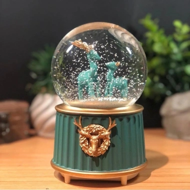 Pilli Işıklı Müzikli Kar Küresi–İki Geyikli Yeşil Figürlü Eğlenceli Masaüstü Biblo, LED Aydınlatmalı Dekoratif Hediyelik Kar Küresi (5468)