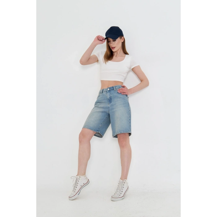 Yüksek bel, tintli yıkama uzun baggy kadın kot şort. Rahat kalıbıyla modern, şık ve konforlu bir stil sunar.