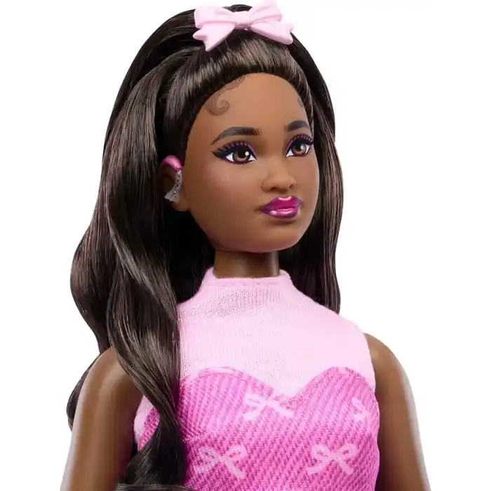 Kurdele desenli pembe kot üst ve etek giyen, işitme cihazı ve el çantası gibi aksesuarlar takan siyah saçlı Barbie Deluxe Style bebek (10), JJN70