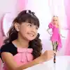 Barbie Deluxe Style bebek (15), klasik Barbie tarzında pembe elbise, at kuyruğu yapılmış sarı saçlar, siyah dantelli çorap, gümüş rengi el çantası ve gümüş takılar, JJN73